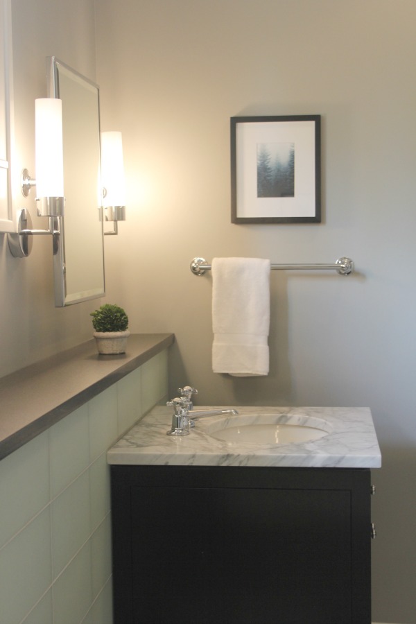 Benjamin Moore Stonington Gray in a luxurious bathroom with glass tile and black vanity. #hellolovelystudio #bathroomdesign #benjaminmoore #stoningtongray #greywalls #luxurybathroom