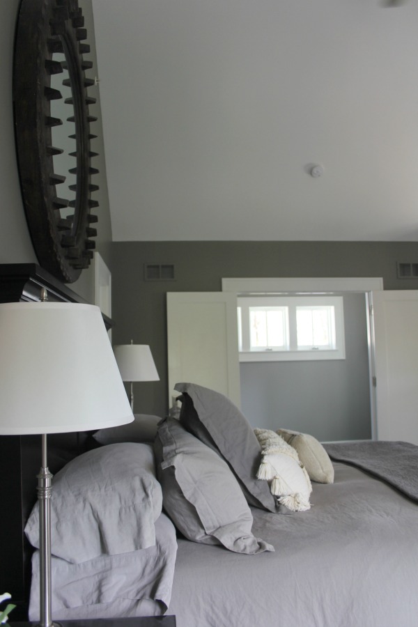 Serene and minimal interior design inspiration from an industrial farmhouse style bedroom with Benjamin Moore Platinum Gray paint color on walls. Photo: Hello Lovely Studio.