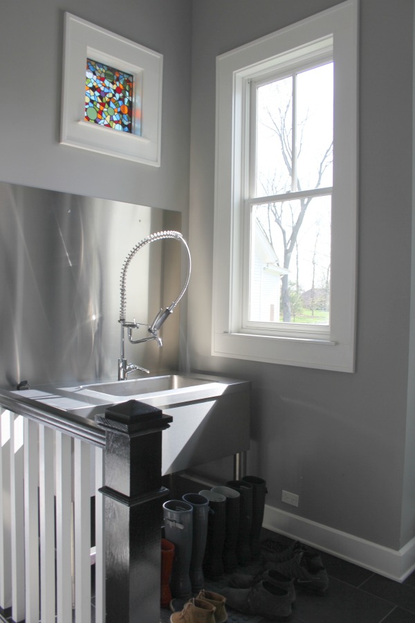 Beaux murs gris (Benjamin Moore Stonington Grey) dans un vestiaire de ferme industrielle avec pulvérisateur industriel à un évier en acier inoxydable. #hellolovelystudio #modernfarmhouse #mudroom #benjaminmoore #stoningtongray #greypaint