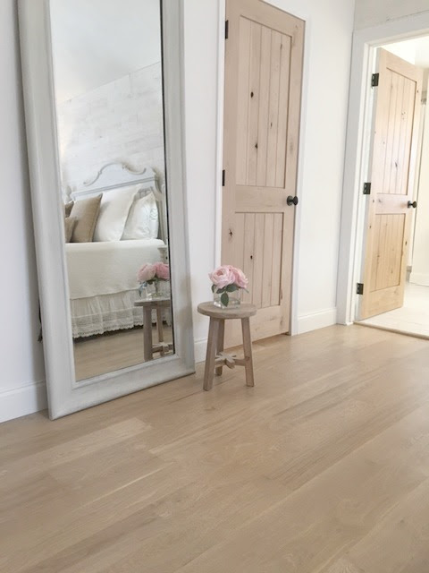 My master bedroom with white oak hardwood flooring and rustic alder doors - Hello Lovely Studio.