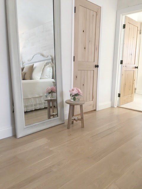 Nordic French white bedroom with light grey, linen, and white. Stikwood on wall, alder doors, cottage style furniture, and white oak flooring. #hellolovelystudio #bedroom #frenchcountry #nordicfrench #stikwood #serene #romantic #whitebedroom