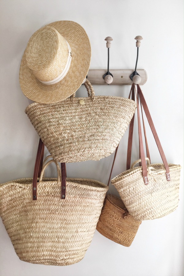 Charming French market baskets from Vivi et Margot hang from a vintage hook rack. #vivietmargot #frenchmakret #frenchbaskets #marketbaskets #summerliving #rusticdecor #frenchcountry