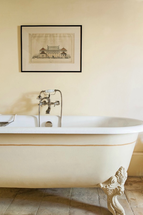 Clawfoot tub in an elegant French country bathroom with antique tile floor in Provence - Haven In.