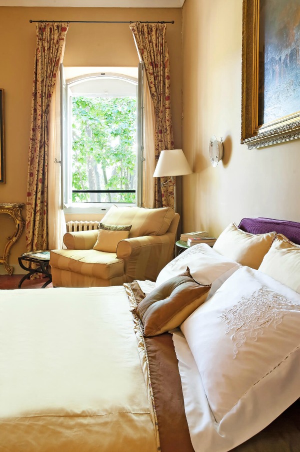 Warm golden yellow tones in an elegant French country bedroom in a Provence chateau - Haven In.