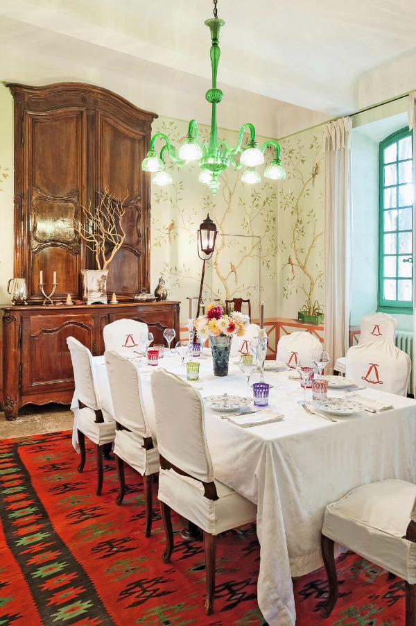 French country dining room with handpainted murals on walls, slipcovered chairs, and traditional antiques. #diningroom #provence #frenchcountry