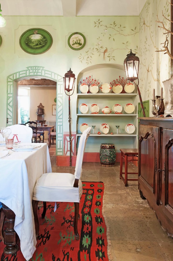 Painted murals, green, antiques, and slipcovered dining chairs in a charming traditional dining room in Provence. #frenchcountry #murals