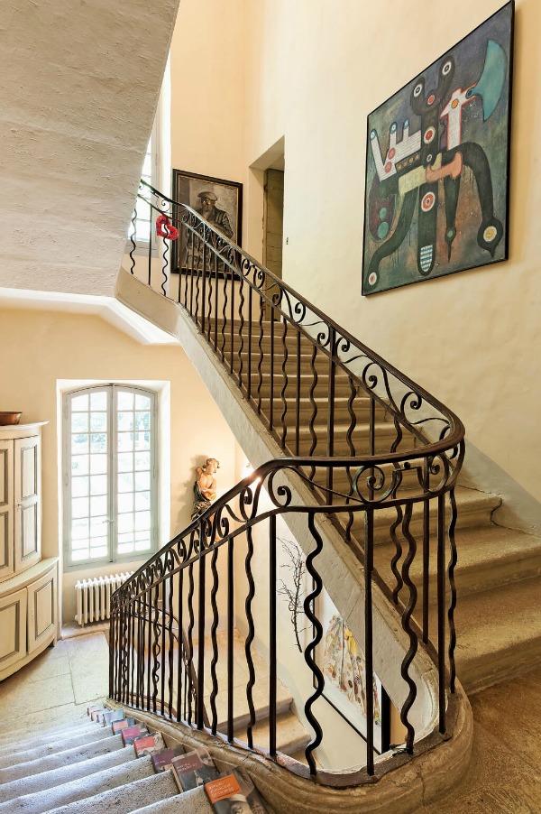 A whimsical wrought iron staircase railing and stone steps delight guests to this Provence chateau - Haven In.