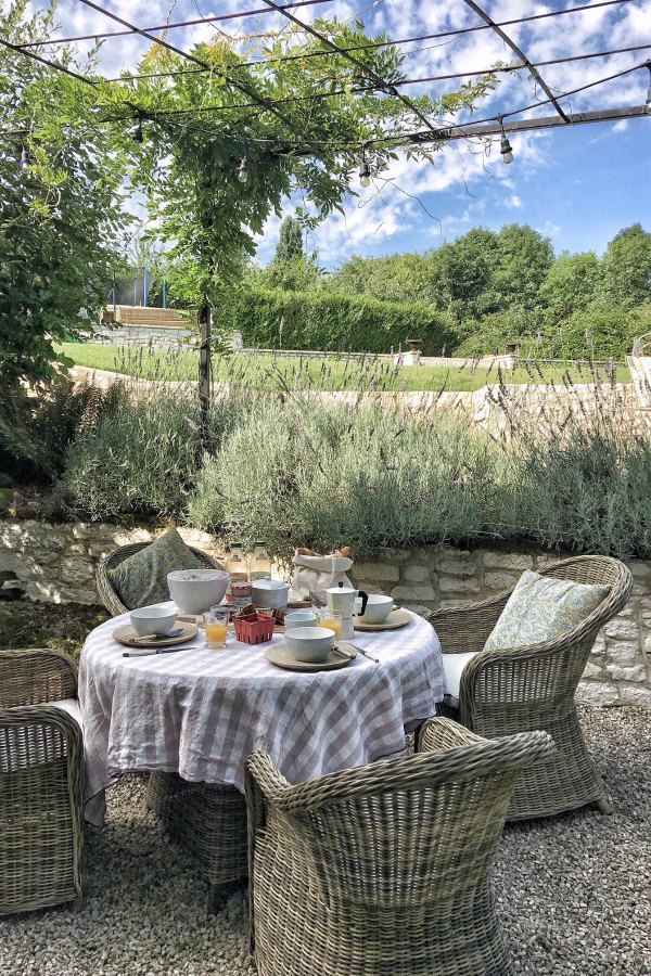 Outdoor dining in a French courtyard. Blush tablecloth by Vivi et Margot. #vivietmargot #frenchfarmhouse #outdoor #dining #kubu