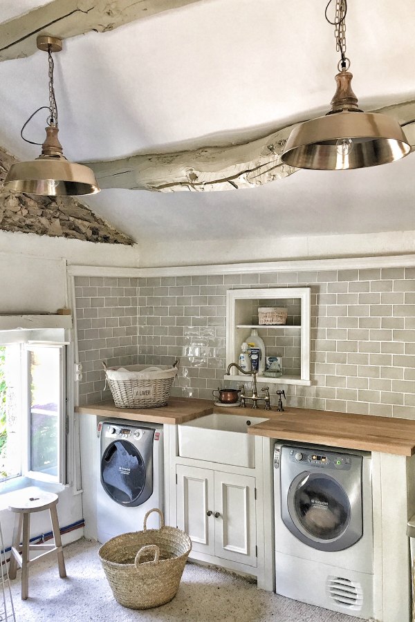 A charming laundry room with grey subway tile and rustic original ceiling beams is a vision of lovely in a farmhouse in France.  #laundryroom #interiordesign #frenchfarmhouse #rusticdecor #vivietmargot #subwaytile