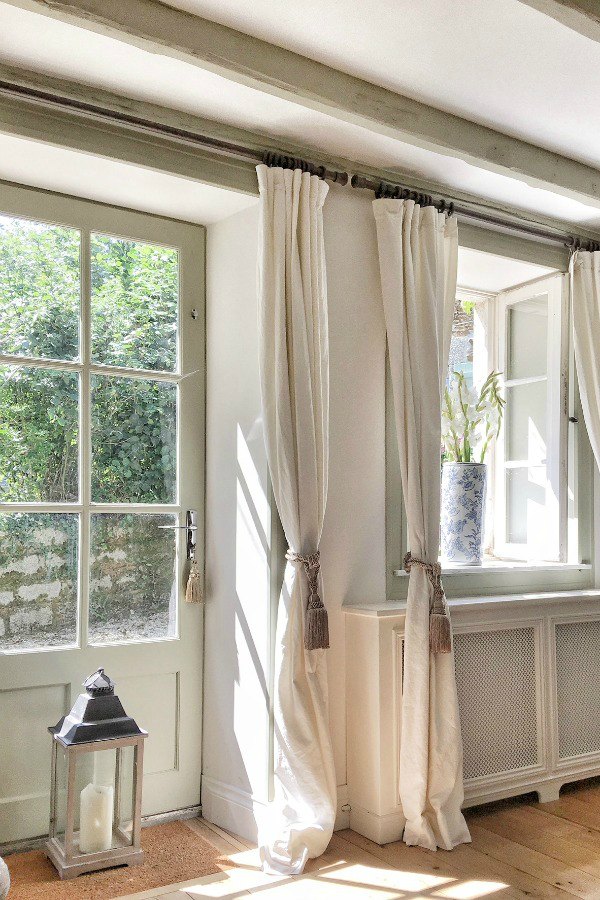 Belgian linen draperies and woodwork painted F&B French Gray adorn a living room. #frenchhome #frenchcountry #livingroom #belgianlinen #vivietmargot