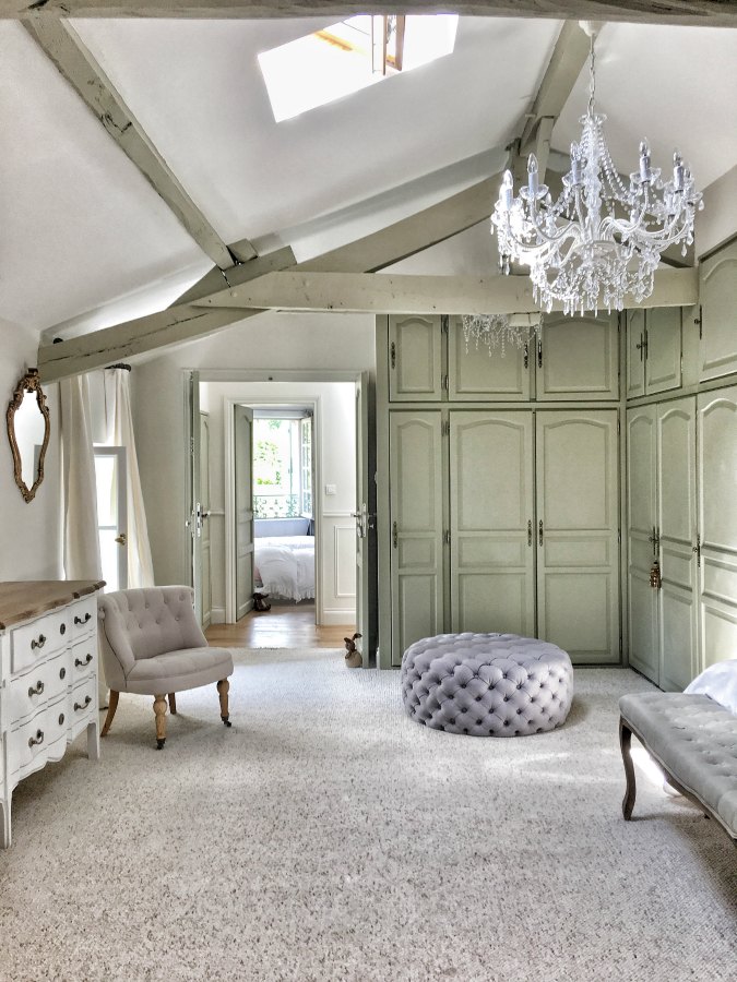 Country French bedroom with built-ins, crystal chandelier, and tufted accessories. #vivietmargot #bedroomdecor #romanticbedroom #interiordesign #frenchhome