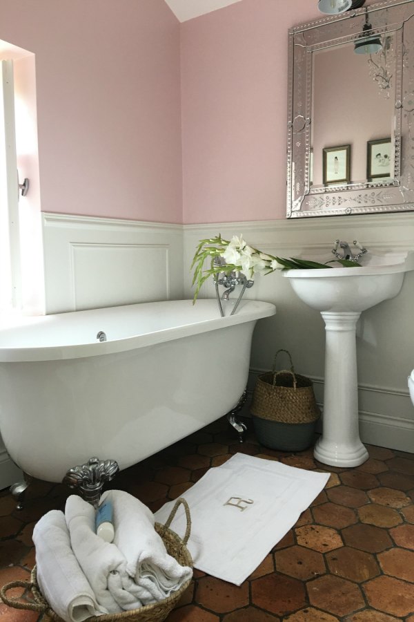 Farrow and Ball Middleton Pink walls in girls bathroom in French farmhouse by Vivi et Margot. Reclaimed antique terracotta tile flooring. Clawfoot tub and pedestal sink. #bathroom #farrowandball #middletonpink #clawfoottub #vivietmargot #terracottatilefloor #authentic #frenchcountry