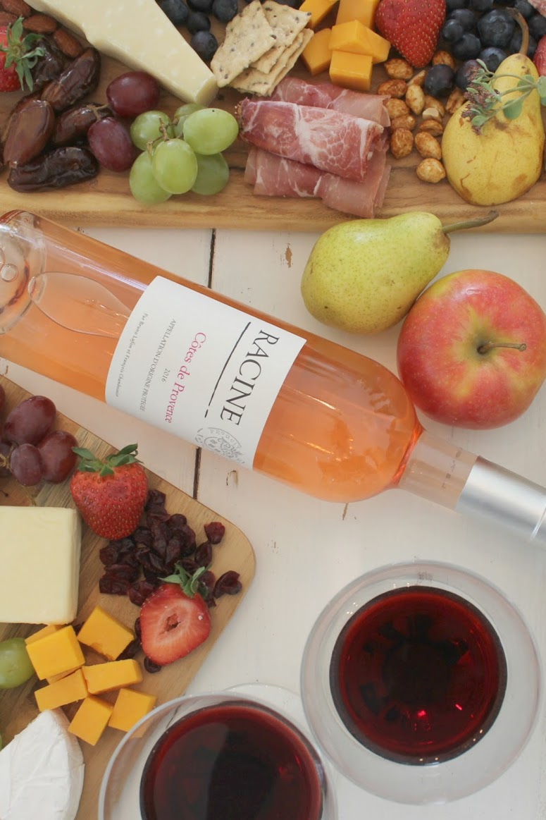 Colorful fall snacks on a farm table with wine. Hello Lovely Studio. #hellolovelystudio #falltablescape #cheeseboard #wineandcheese 