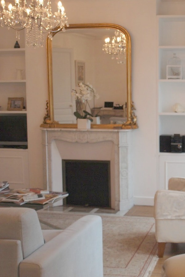 White marble surround fireplace in a Paris apartment. Hello Lovely Studio. #parisapartment #fireplace #crystalchandelier