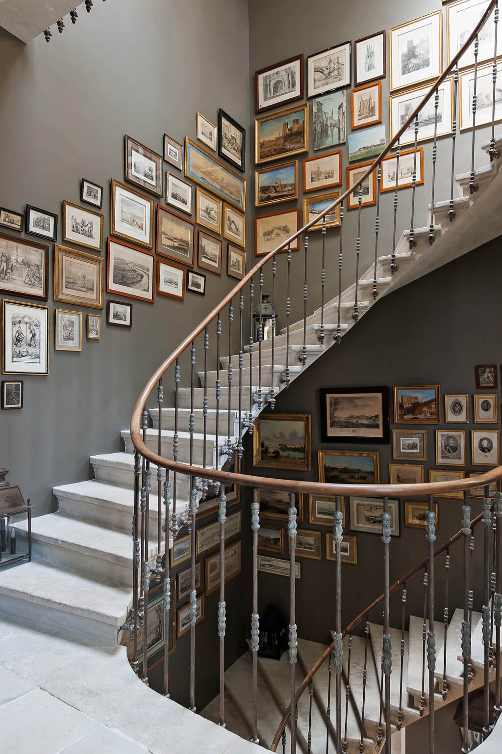 Framed art and stunning French iron staircase. Come see a Breathtaking French Château Tour in Provence With Photo Gallery of Historical Architecture, Dramatic Eclectic Interiors & Oddities!