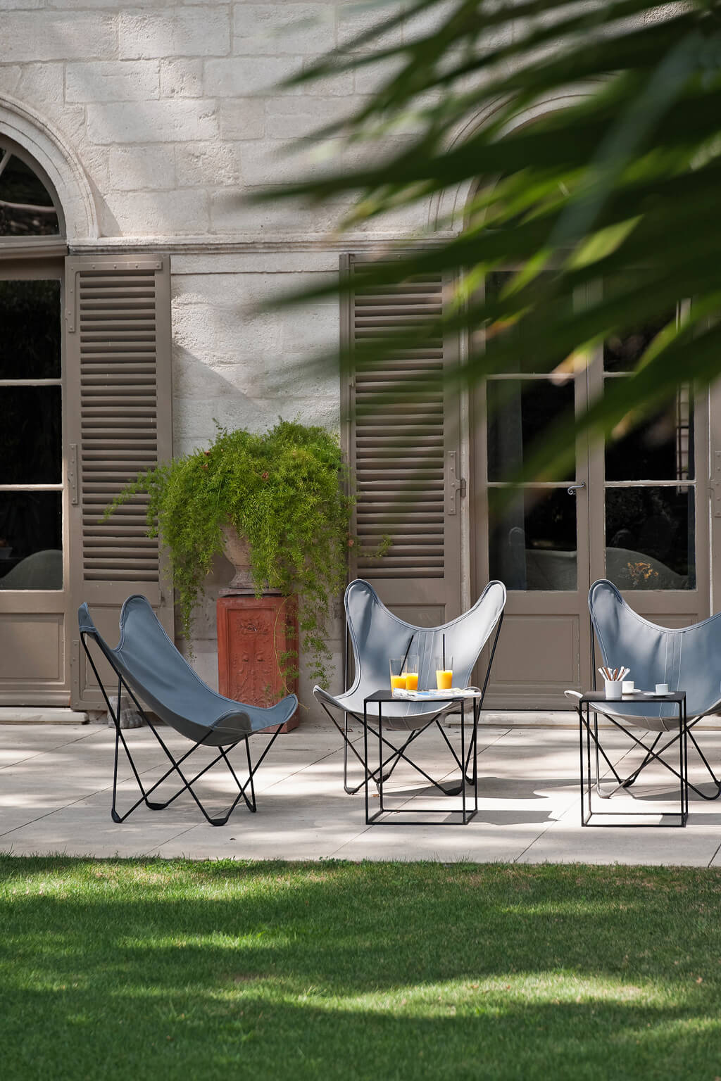 Butterfly chairs on an Avignon patio. Come see a Breathtaking French Château Tour in Provence With Photo Gallery of Historical Architecture, Dramatic Eclectic Interiors & Oddities!