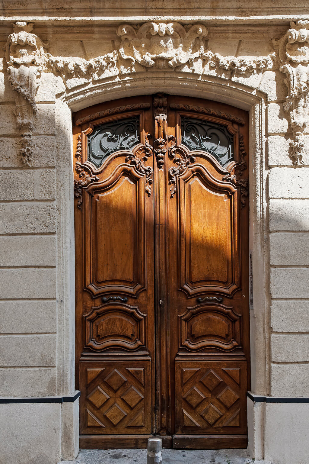 Magnificent antique French wood doors and limestone facade. Photo: Haven In.