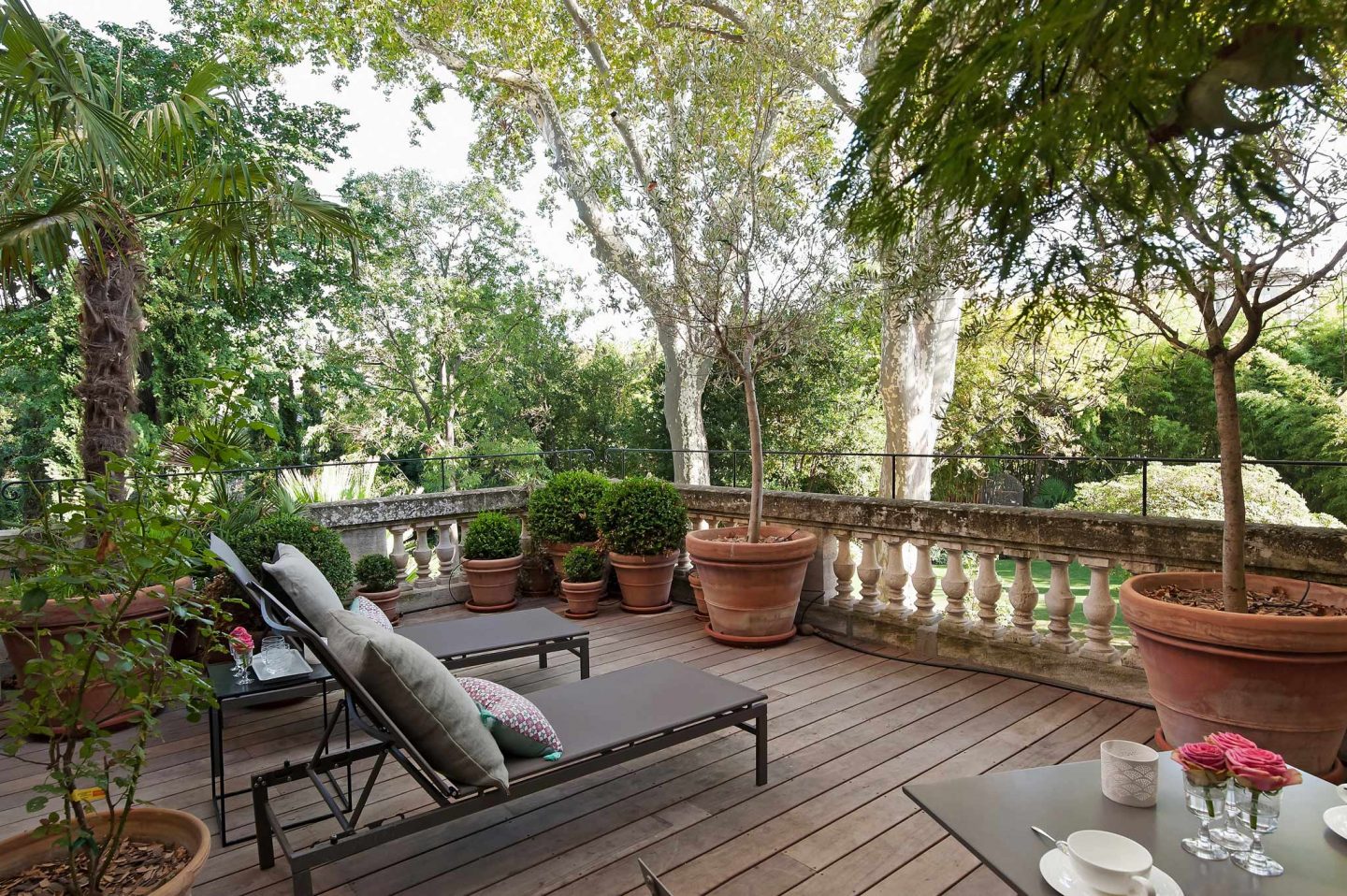 Terrace overlooking a lush garden in Avignon. Serene French Country Style interior design inspiration. The Serenity Suite at Avignon Hôtel Particulier. Luxurious and timeless restored 19th century French chateau in the South of France. Provencal romance, traditional architecture, modern French design, unique art, and European antiques. Photo: Haven In.