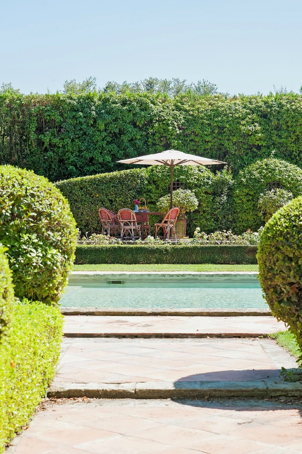 Boxwood and lush formal French gardens surround a pool at a Provence vacation home.