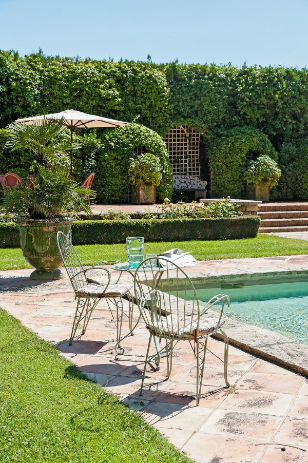 Luxurious and formal French gardens surround a pool at an elegant French chateau in Provence available through Haven In.