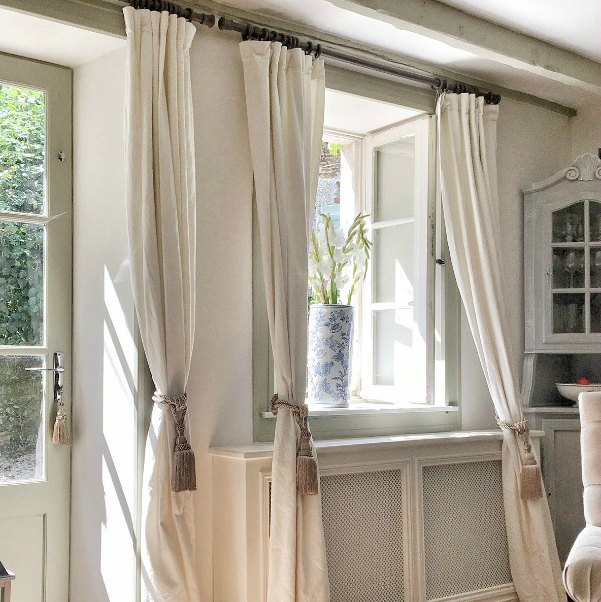 A restored farmhouse in France is decorated with pale draperies and simple furnishings. #vivietmargot #livingroom #frenchfarmhouse