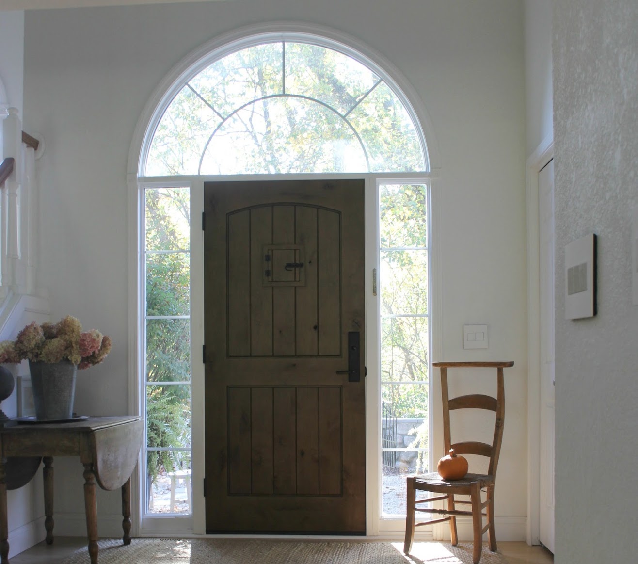 Entry with rustic alder door, French prayer chair, and simple serene fall decor. Hello Lovely Studio.#hellolovelystudio #entry #frontdoor