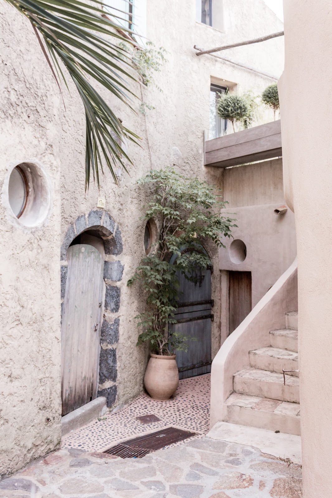 Rustic French Country Doors in Provence and gorgeous curb appeal with climbing vines, crumbling stone, and weathered age. Photo: The Flying Dutchwoman. #provence #southoffrance #exteriors #weathereddoors #rusticdoor #frenchcountryside #summerinfrance #frenchcountry #frenchfarmhouse #frontdoor #sttropez