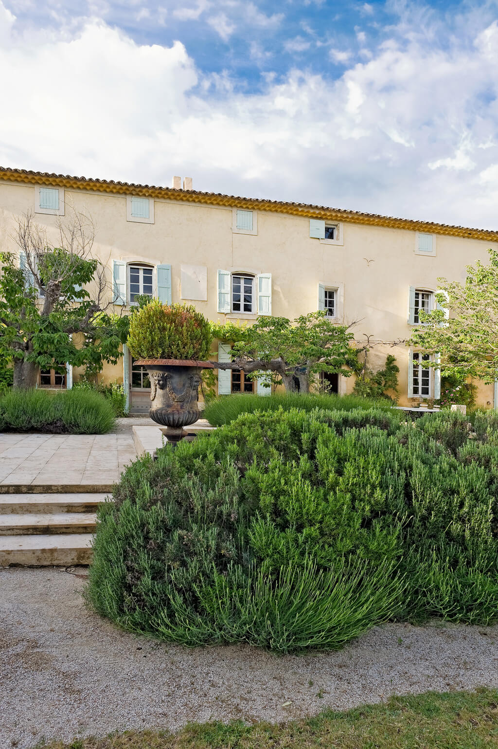 Beautiful light green shutters and sunny yellow stucco exterior of a Provence French country villa vacation house by Haven In.