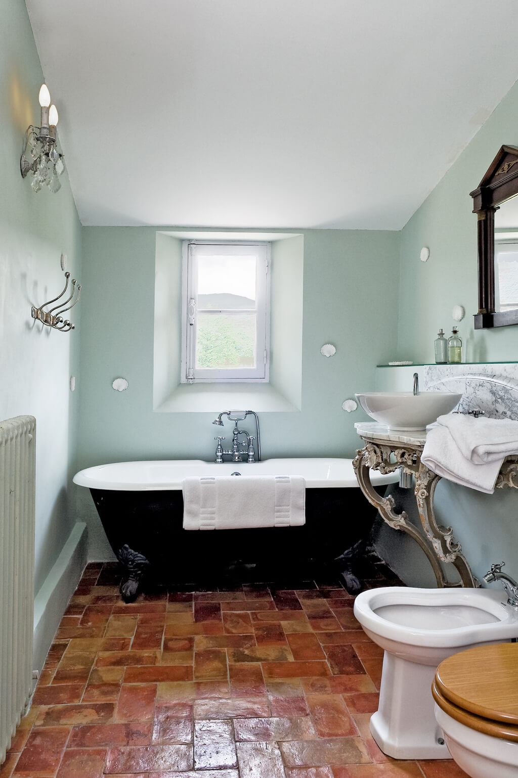 Vintage style bathroom in a French farmhouse with terracotta tile floor.