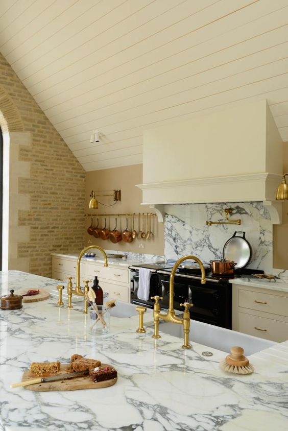 Breathtaking, elegant, and rustic luxe English country kitchen by deVOL kitchens in the UK with bespoke cabinetry, AGA stove, steel windows and doors, woven pendants, and copper accents. Interior design by Susie Atkinson.