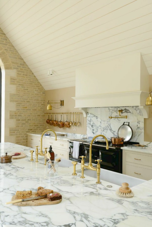 Breathtaking, elegant, and rustic luxe English country kitchen by deVOL kitchens in the UK with bespoke cabinetry, AGA stove, steel windows and doors, woven pendants, and copper accents. Interior design by Susie Atkinson.