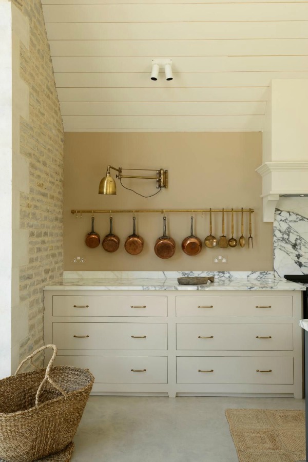 Breathtaking, elegant, and rustic luxe English country kitchen by deVOL kitchens in the UK with bespoke cabinetry, AGA stove, steel windows and doors, woven pendants, and copper accents. Interior design by Susie Atkinson.