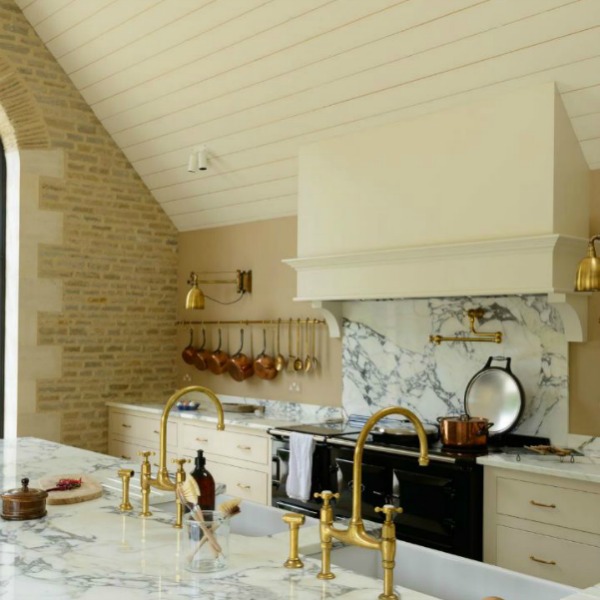 Breathtaking, elegant, and rustic luxe English country kitchen by deVOL kitchens in the UK with bespoke cabinetry, AGA stove, steel windows and doors, woven pendants, and copper accents. Interior design by Susie Atkinson.