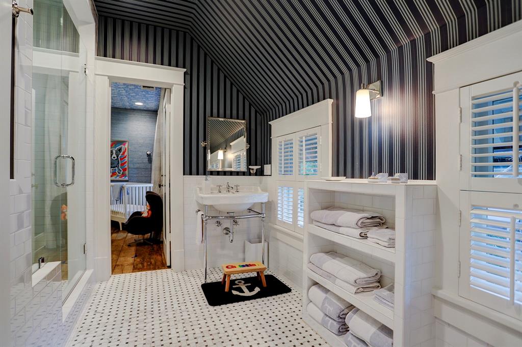 Stripe wallpaper in a 1920s white bathroom. Luxurious interior design details in a Tudor Revival house renovation in Houston. Design consultant: Pam Pierce. Many reclaimed antique materials from Chateau Domingue. #housetour #oldworld #pampierce #chateaudomingue #europeanantiques #luxurioushome #interiordesignideas #Frenchcountry #limestone #reclaimedflooring #bespoke #houstonhome