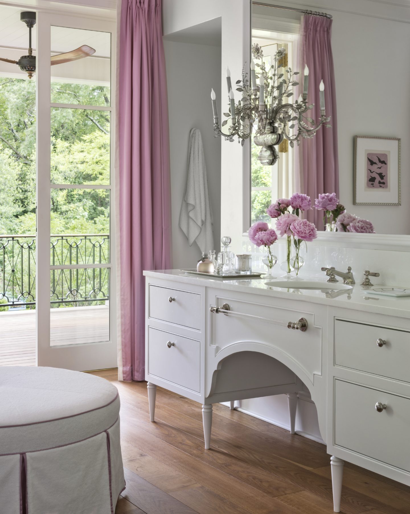 Exquisite and luxurious white bathroom design by Suzanne Kasler with vintage sideboard style vanity and cheerful pink accents.