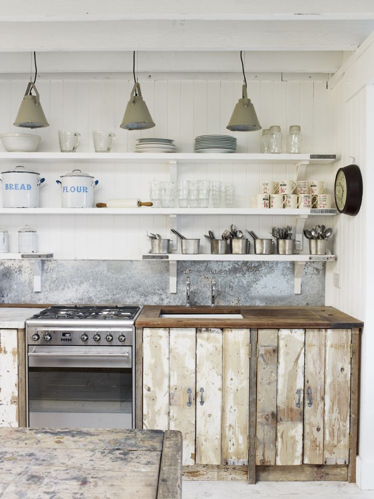 Rustic English country cottage kitchen with heavily distressed handmade cupboards, open shelving, and industrial vintage lighting. #industrialfarmhouse #rustickitchens #distressedwood