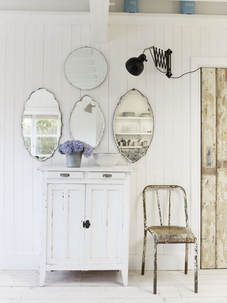 A gorgeous shabby chic vignette with vintage mirrors massed over a country painted cabinet. The Beach Studios. Atlanta Bartlett & Dave Coote. #shabbychic #interiordesign #vintagestyle #whitecottage #mirrors #romanticdecor