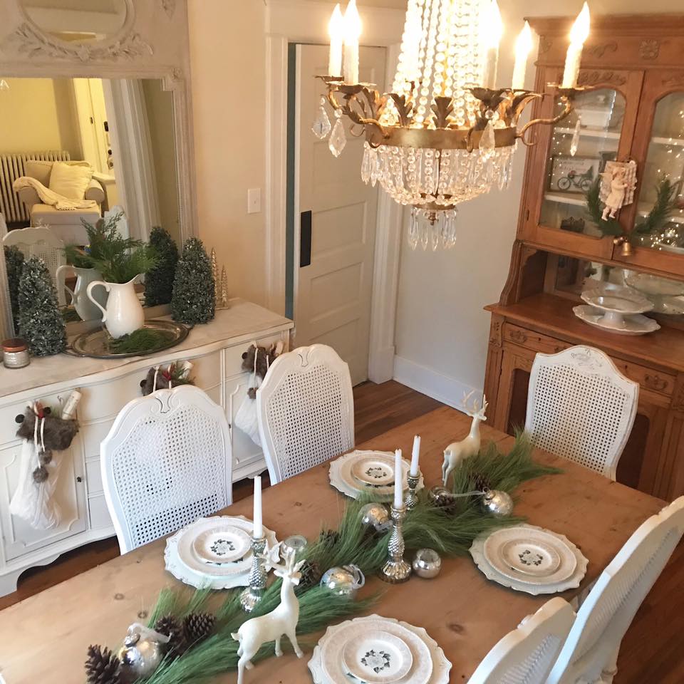 Farmhouse dining room with white shabby chic decor decorated simply for Christmas with greenery, silver balls, and neutral colors. #christmasdecor #diningroom #farmhousedecor #shabbychic