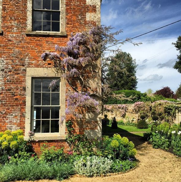 Storybook charm and lovely English Country House Exterior inspiration describe this lovely cottage exterior and gardens. The Beach Studios. Atlanta Bartlett. #Englishcottage #houseexterior #curbappeal #countryhouse #wisteria #rustic #Europeancountry #Englishcountry #cottagestyle