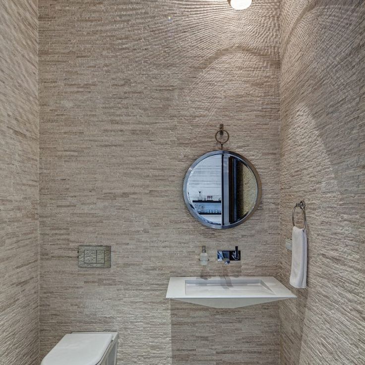 Powder room with walls tiled floor to ceiling with stone. Beautiful interior design inspiration from Chicago designer Cari Giannoulias on Hello Lovely Studio. #hellolovelystudio #interiordesign #carigiannoulias #chicagodesigner #interiordesigner #sophisticateddecor #understated #luxurydecor