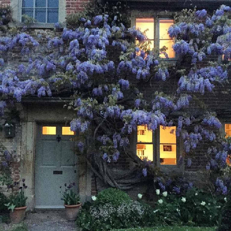 Charming English country cottage with wisteria and weathered brick for a storybook exterior! #Englishcountry #Englishcottage #wisteria #cottageexterior #stonecottage #storybook #houseexterior