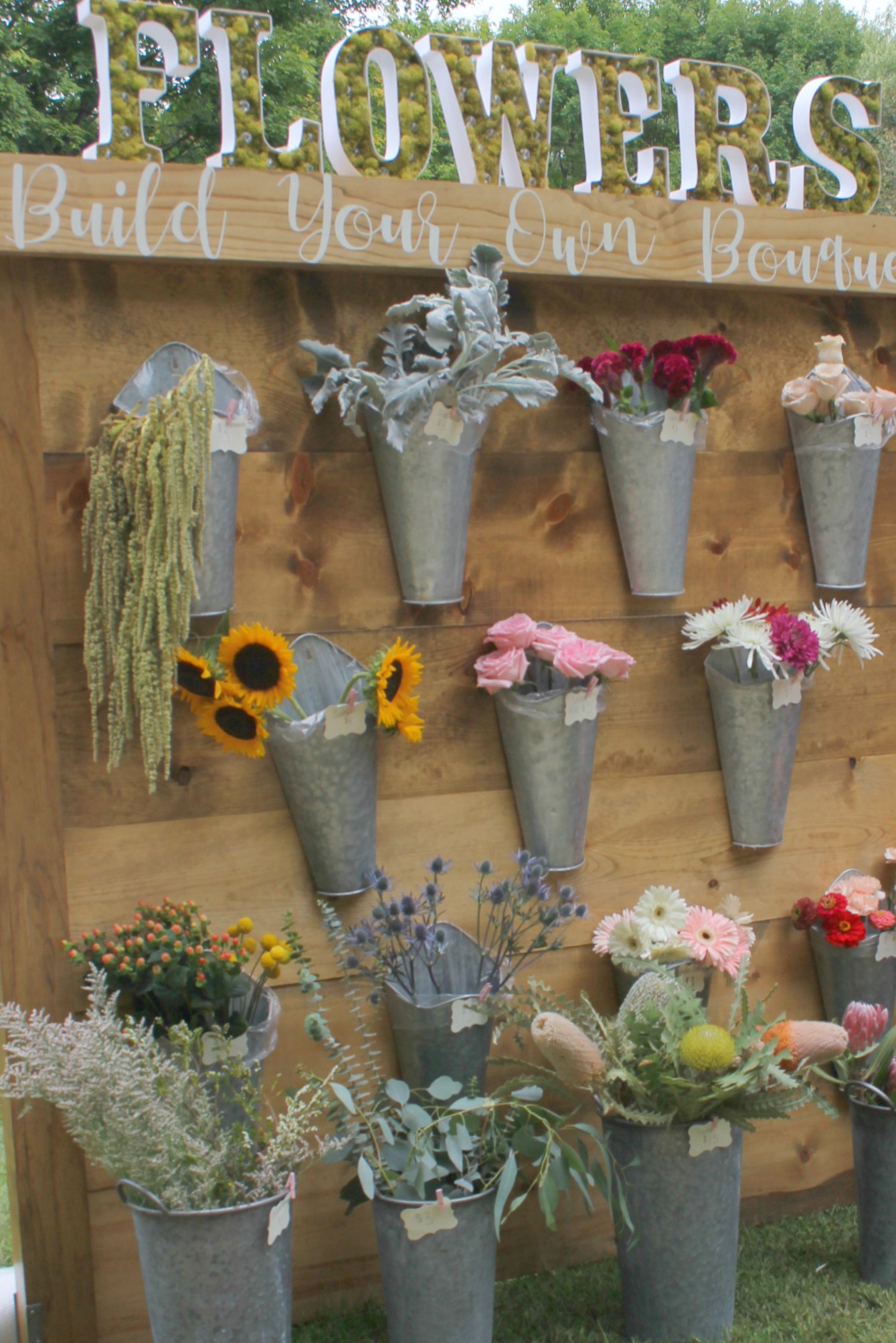 Detail of galvanized farmhouse metal vases with fresh flowers by Evelyn's Acre. So much to love at Main Street Market Rockford in the fall! Hosted by Urban Farmgirl, it draws 150 wonderful vendors from around the country and throngs of shoppers. #hellolovelystudio #mainstreetmarket #rockford #urbanfarmgirl #fleamarket #countrymarket #farmhousedecor #farmhousestyle #midwest #fall