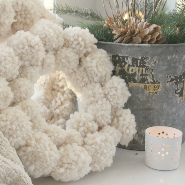 A fuzzy wuzzy wooly ivory handmade pom pom wreath is perfect for a cozy white Christmas! Hello Lovely Studio. #christmasdecor #christmaswreath #pompom #handmade