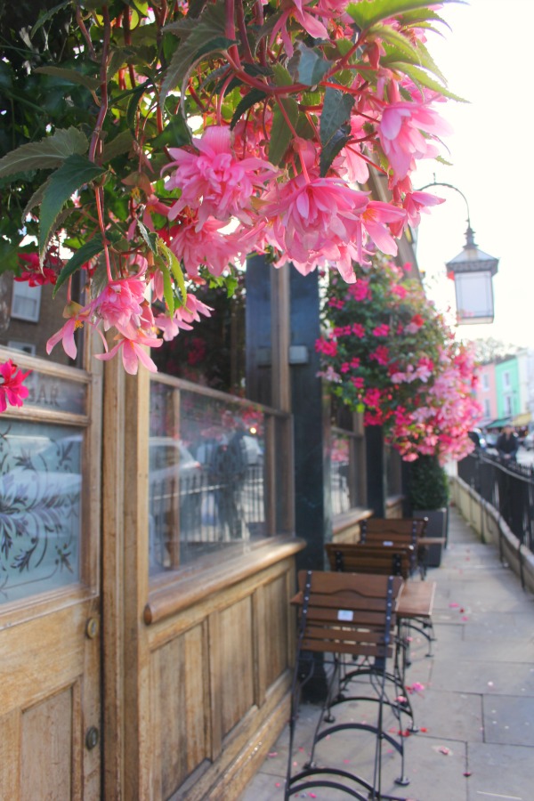 Vibrant cascading pink flowers on an English pub exterior in London by Hello Lovely Studio.