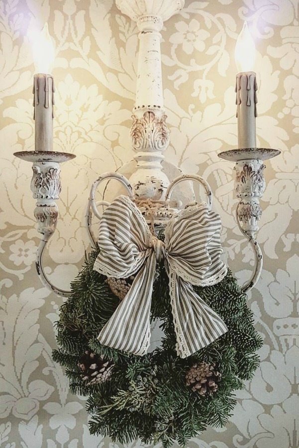 French country sconce with Christmas wreath and striped ribbon. #frenchcountry #christmasdecor #elegantdecor