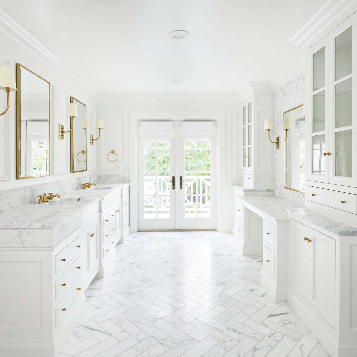 Calcatta marble white bespoke bath by The Fox Group. Herringbone marble floor pattern, French doors, and gilded iron lighting and hardware.