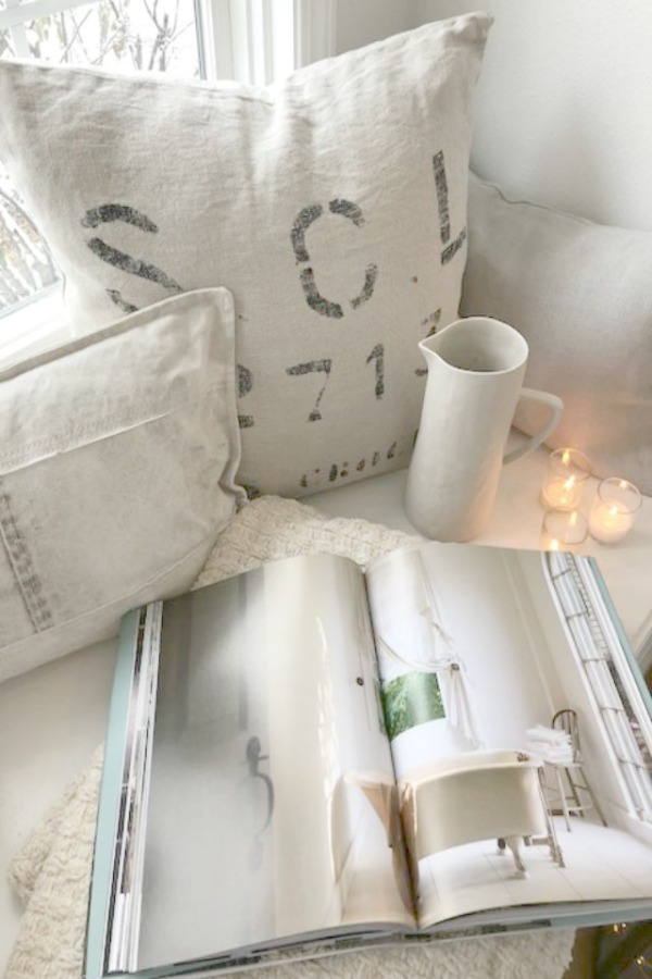 Cozy whites on a window seat in a kitchen by Hello Lovely Studio. #hellolovelystudio #windowseat #swedish #whitedecor #winter