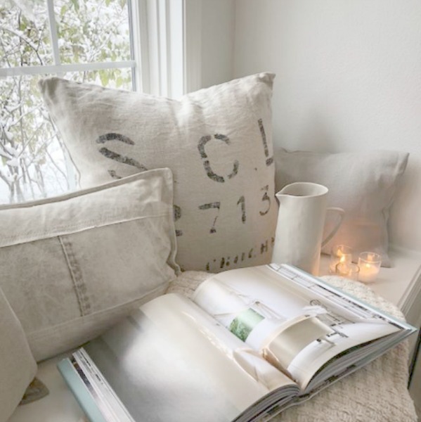 Cozy whites on a window seat in a kitchen by Hello Lovely Studio. #hellolovelystudio #windowseat #swedish #whitedecor #winter