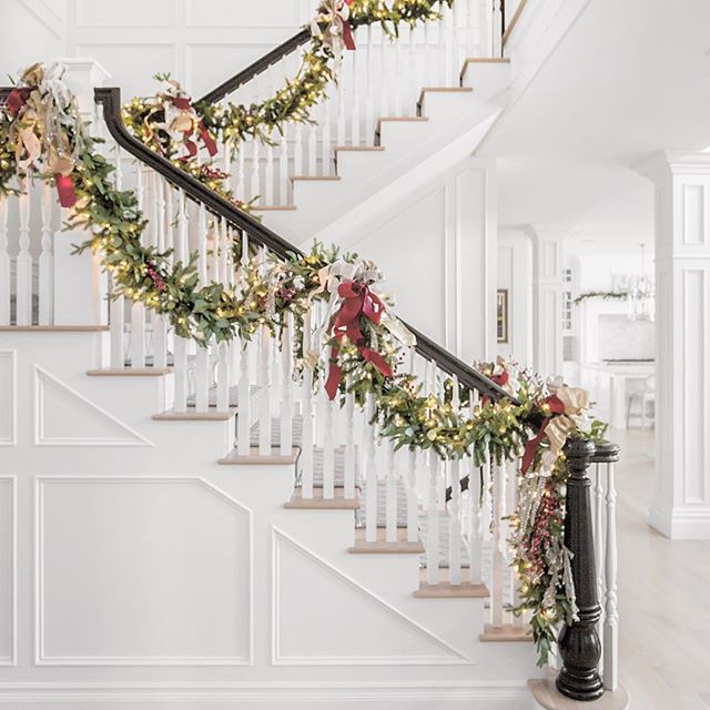 Staircase with gorgeous greenery garland, white lights, and soft red ribbon. #christmasdecor #elegant #garland #staircase