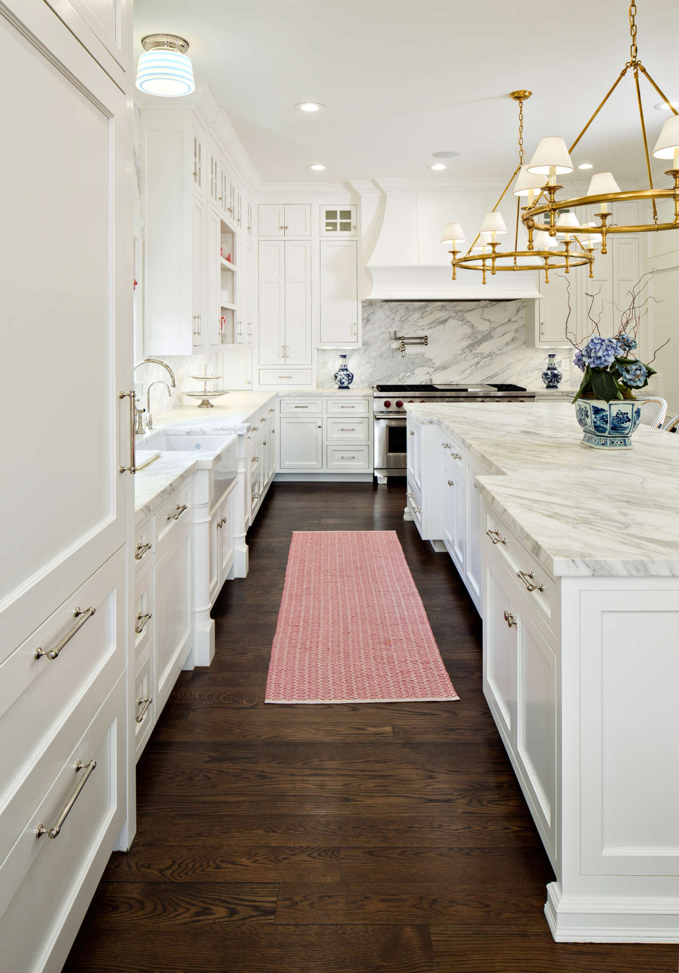 Timeless white kitchen with dark hardwood floors and blue porcelain accents - The Fox Group.